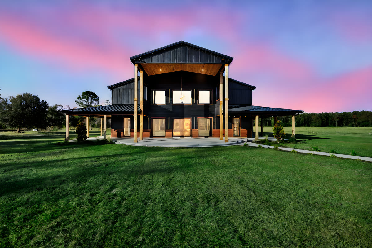 The Venue at dusk under a pink and violet sky, porch lights just coming on