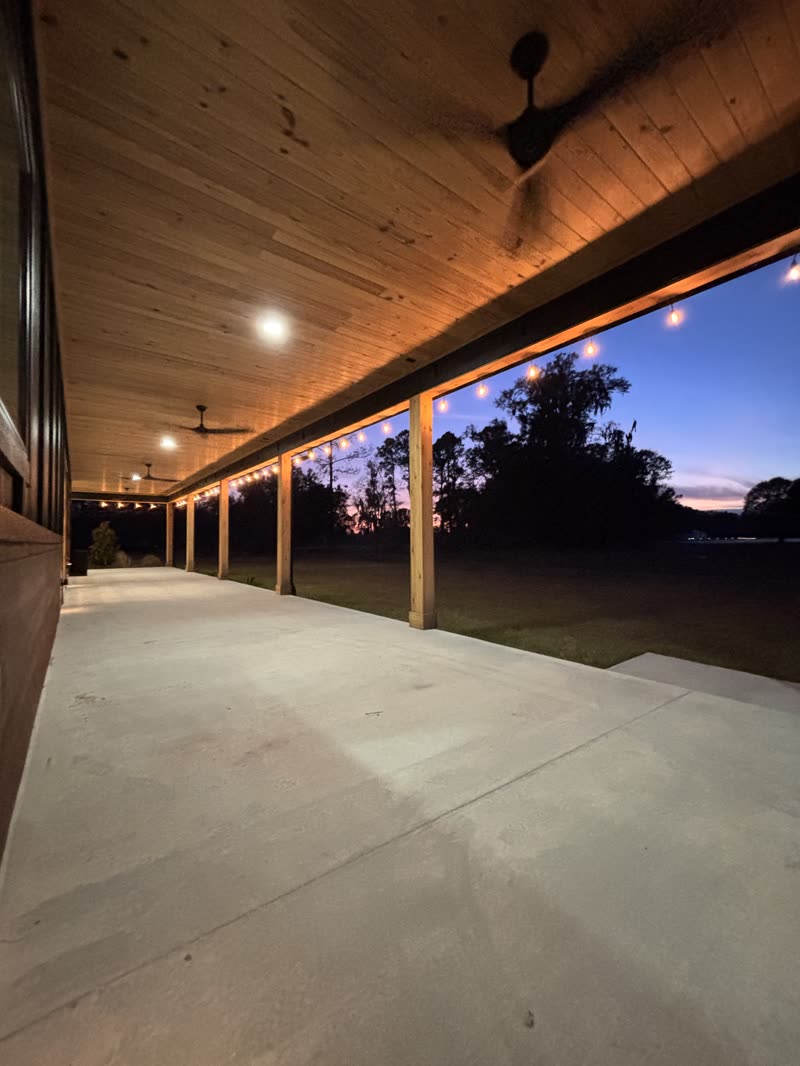 The covered veranda at Three Fours Ranch, lit with string lights at dusk