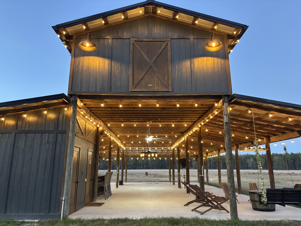 The Pole Barn at dusk, string lights outlining the gable and open bay